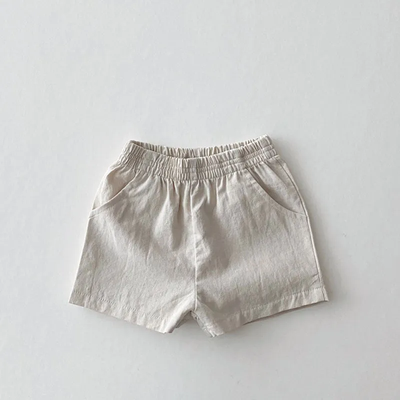 Baby loose thin cotton and linen shorts in black with elastic waist, side view on white background