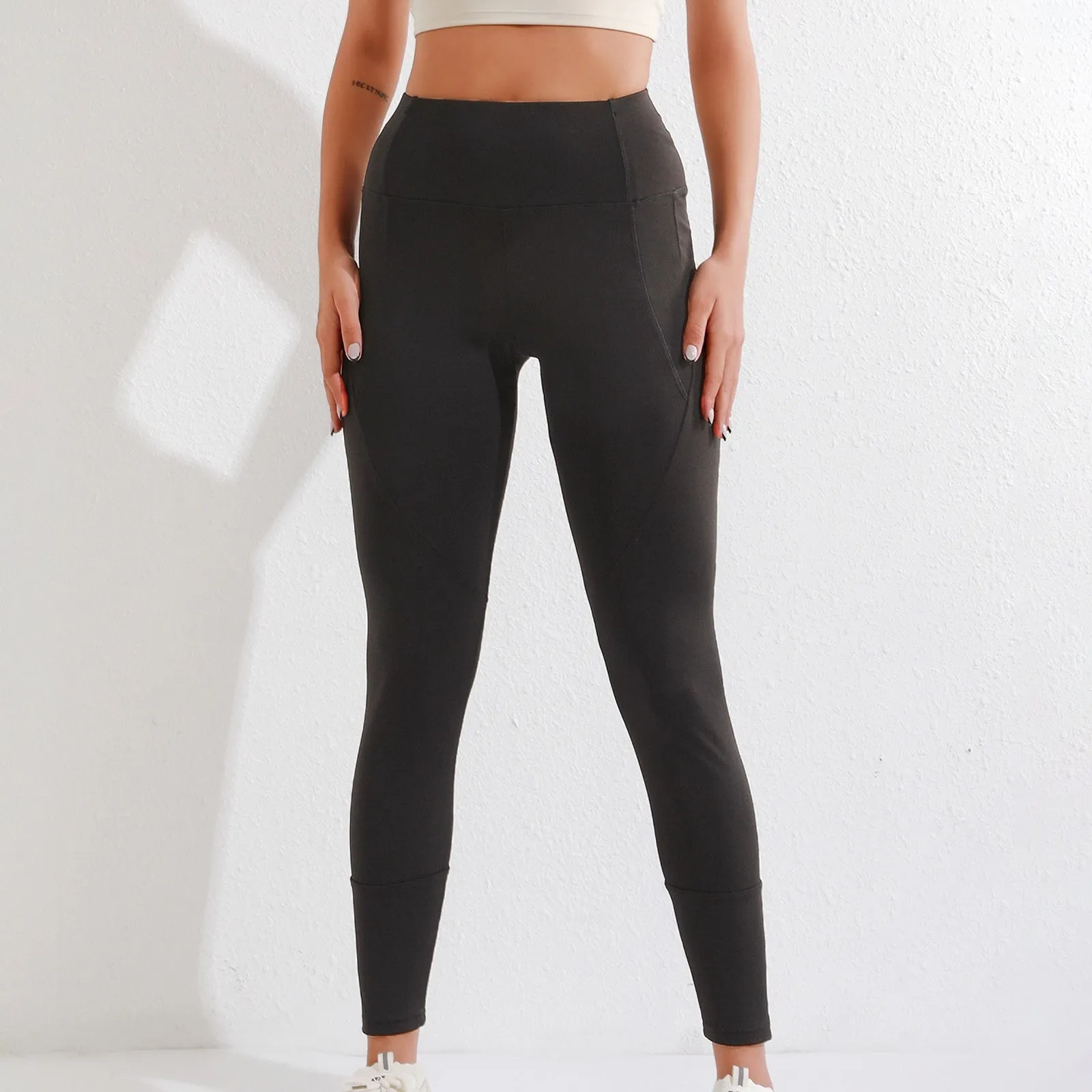 Black cropped leggings with high waist and zipper pocket on a model