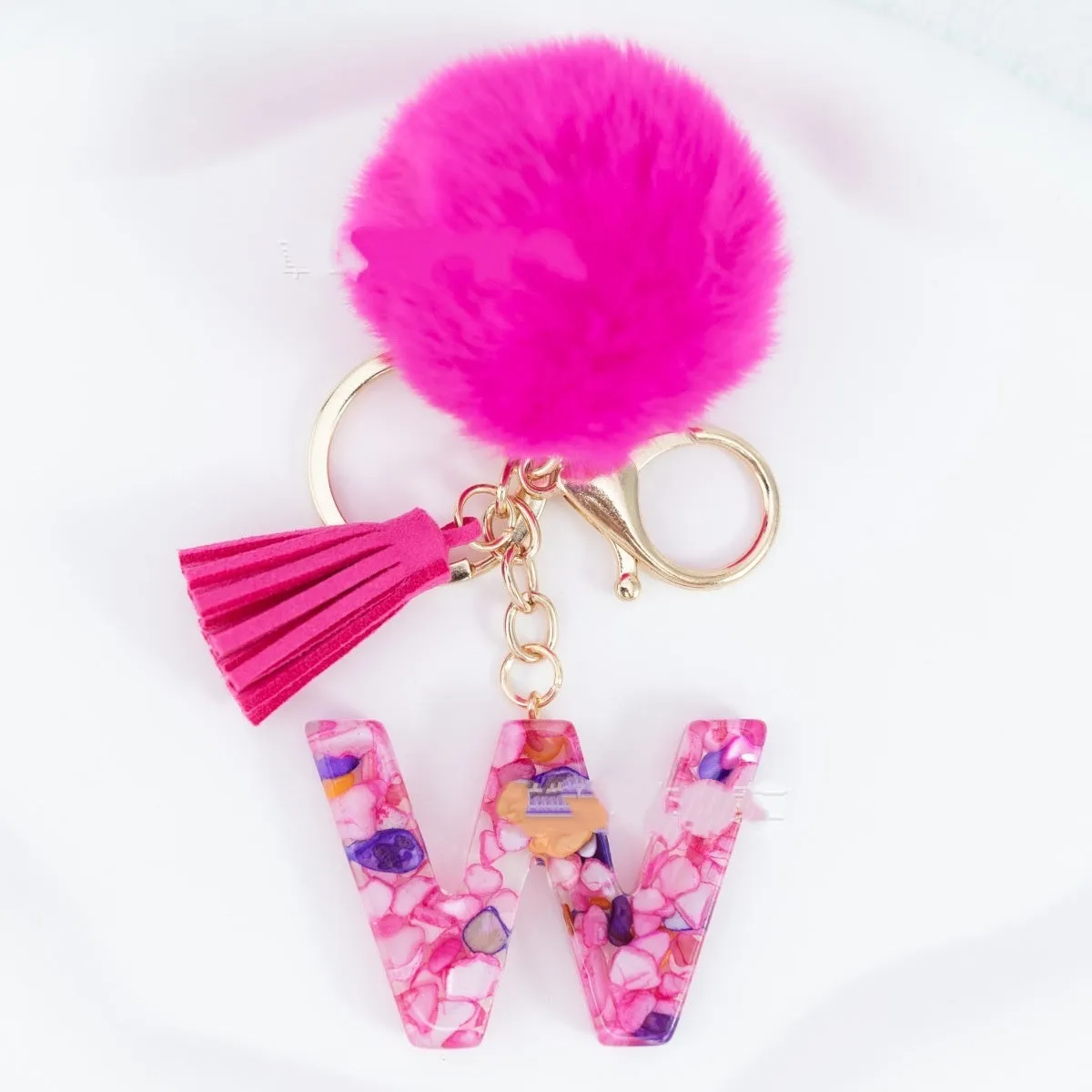Rose red stone keychain with English letter B, fur ball and tassel on a white background