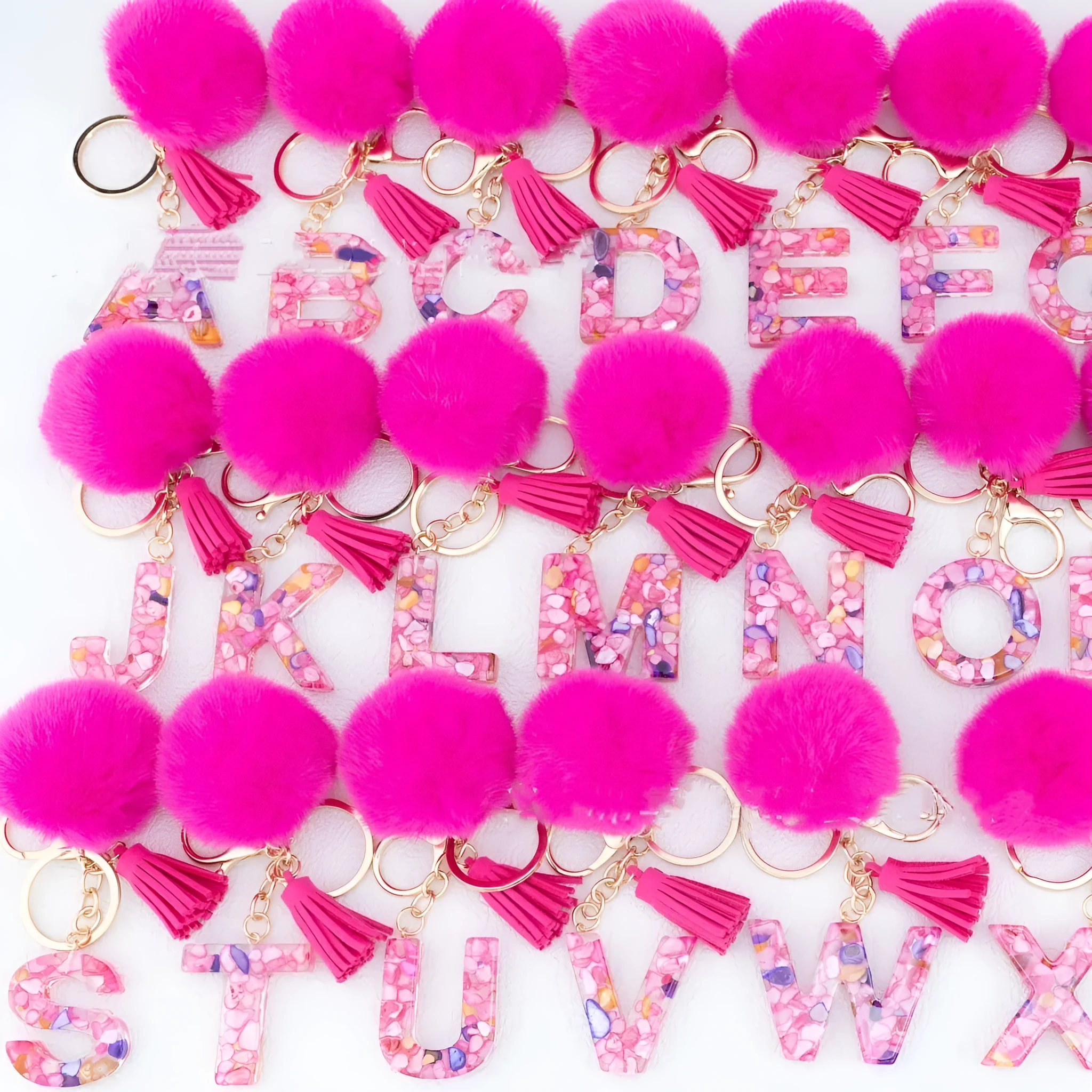 Rose red stone keychain with English letter B, fur ball and tassel on a white background