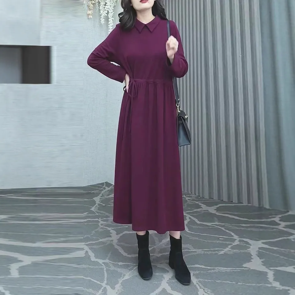 Purplish red plus size long sleeve winter dress for women on a hanger.
