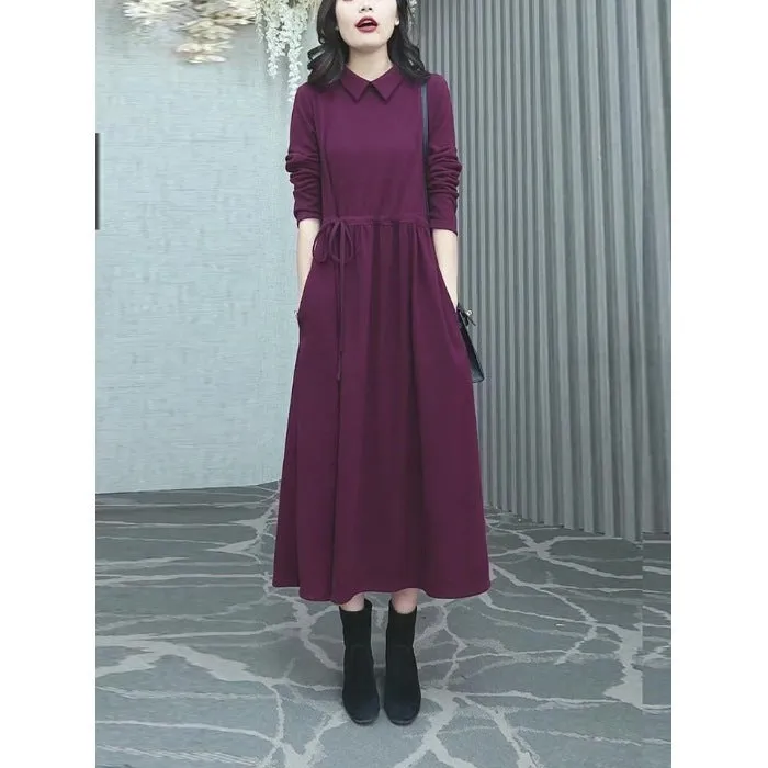 Purplish red plus size long sleeve winter dress for women on a hanger.