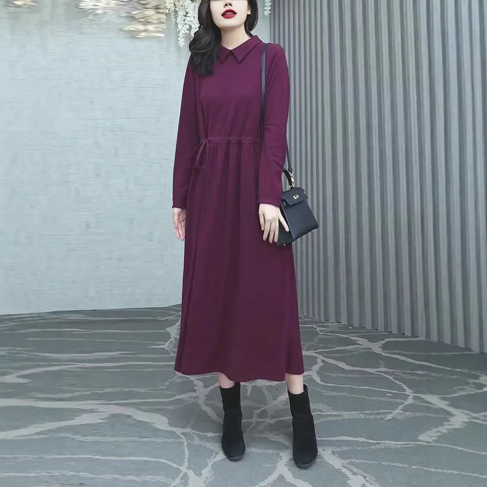 Purplish red plus size long sleeve winter dress for women on a hanger.