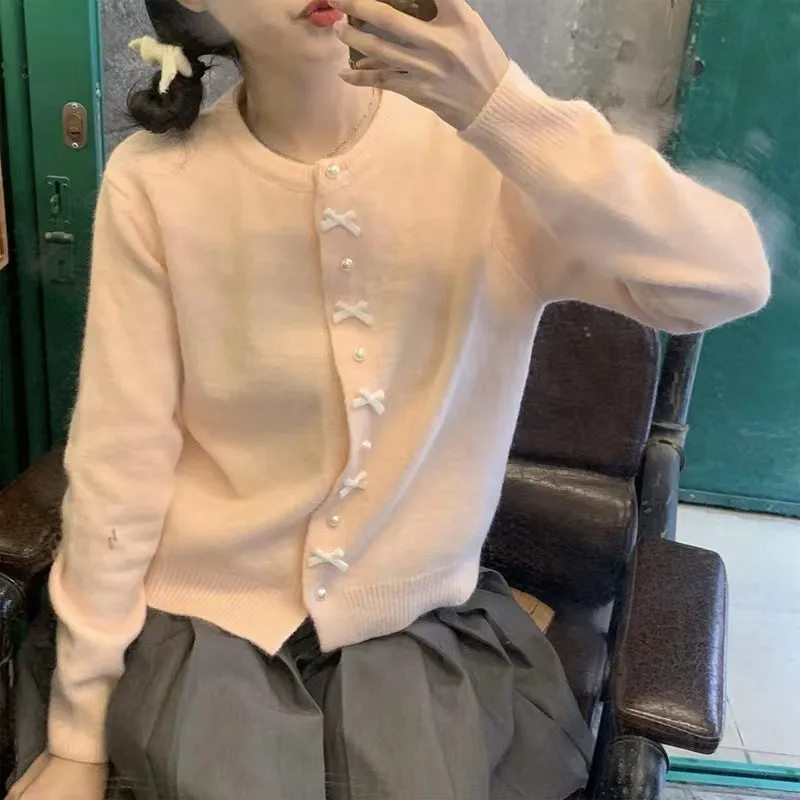 Women's solid colour cardigan sweater with bow and pearl buttons, shown in light yellow.