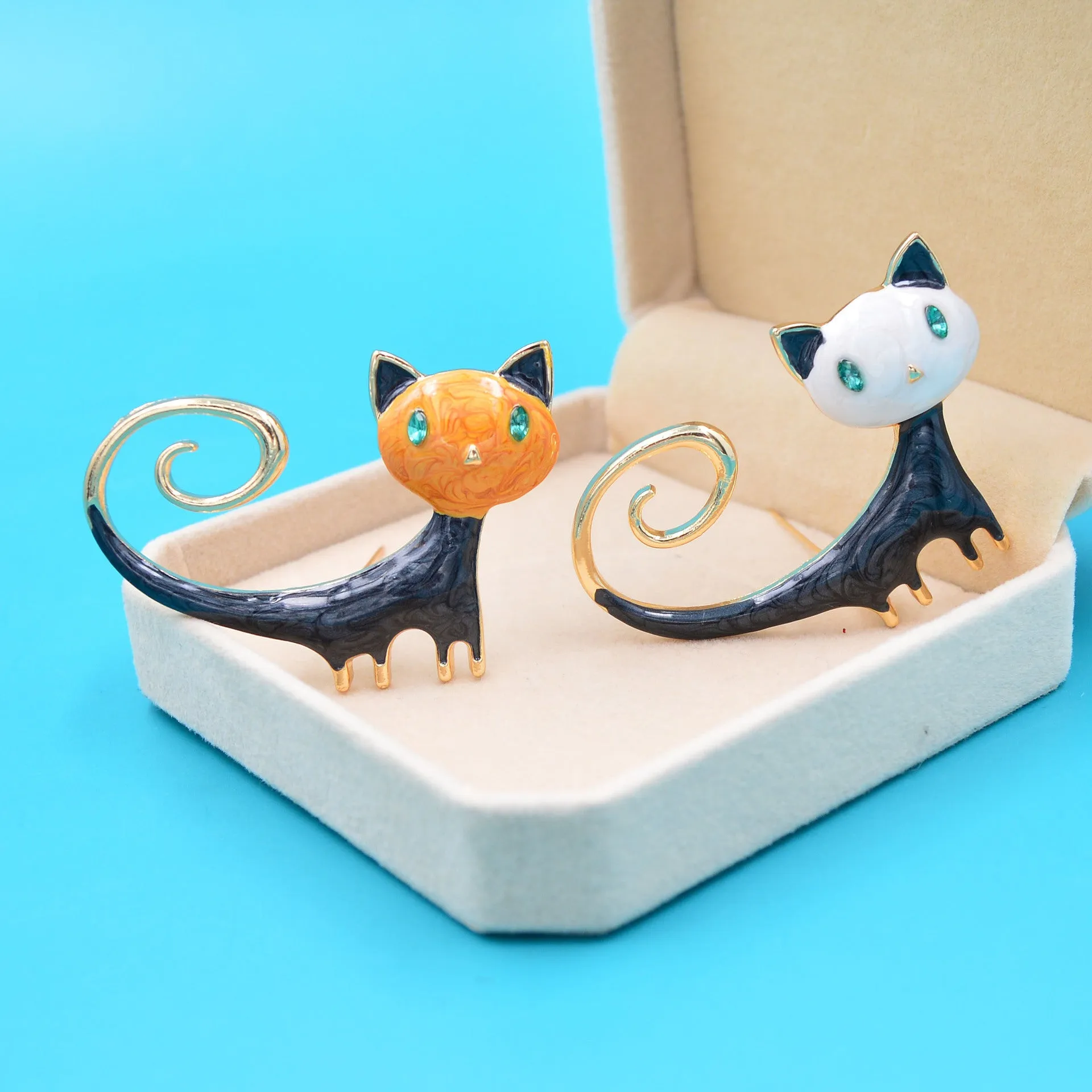 Painted tail-up kitten brooch in white or orange colour on alloy background