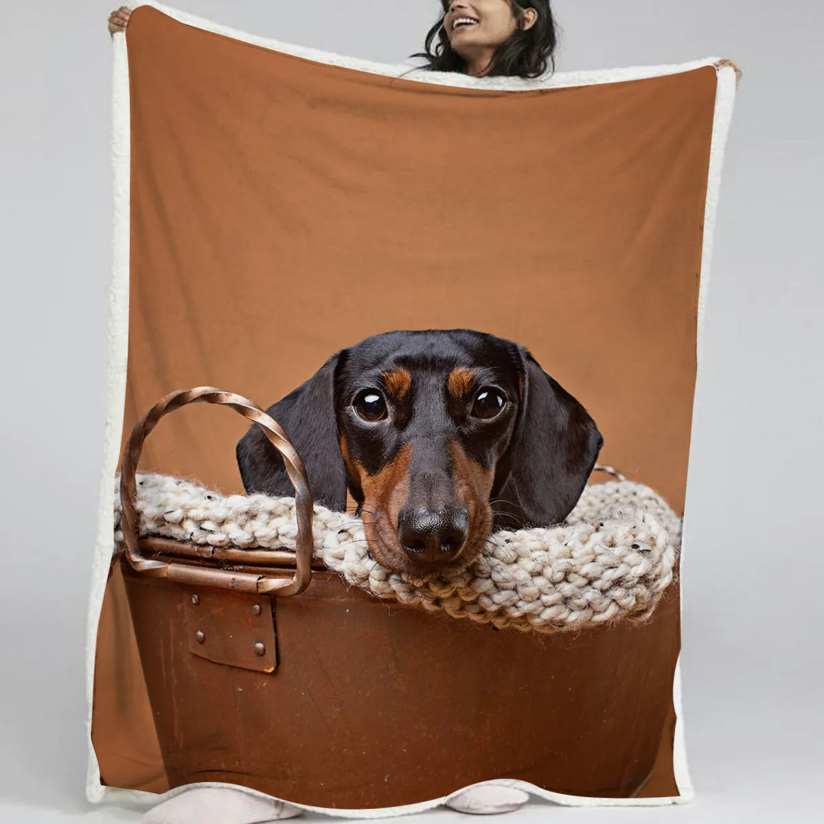 Brown sausage dog themed lamb wool blanket folded on a sofa, 130x150cm size