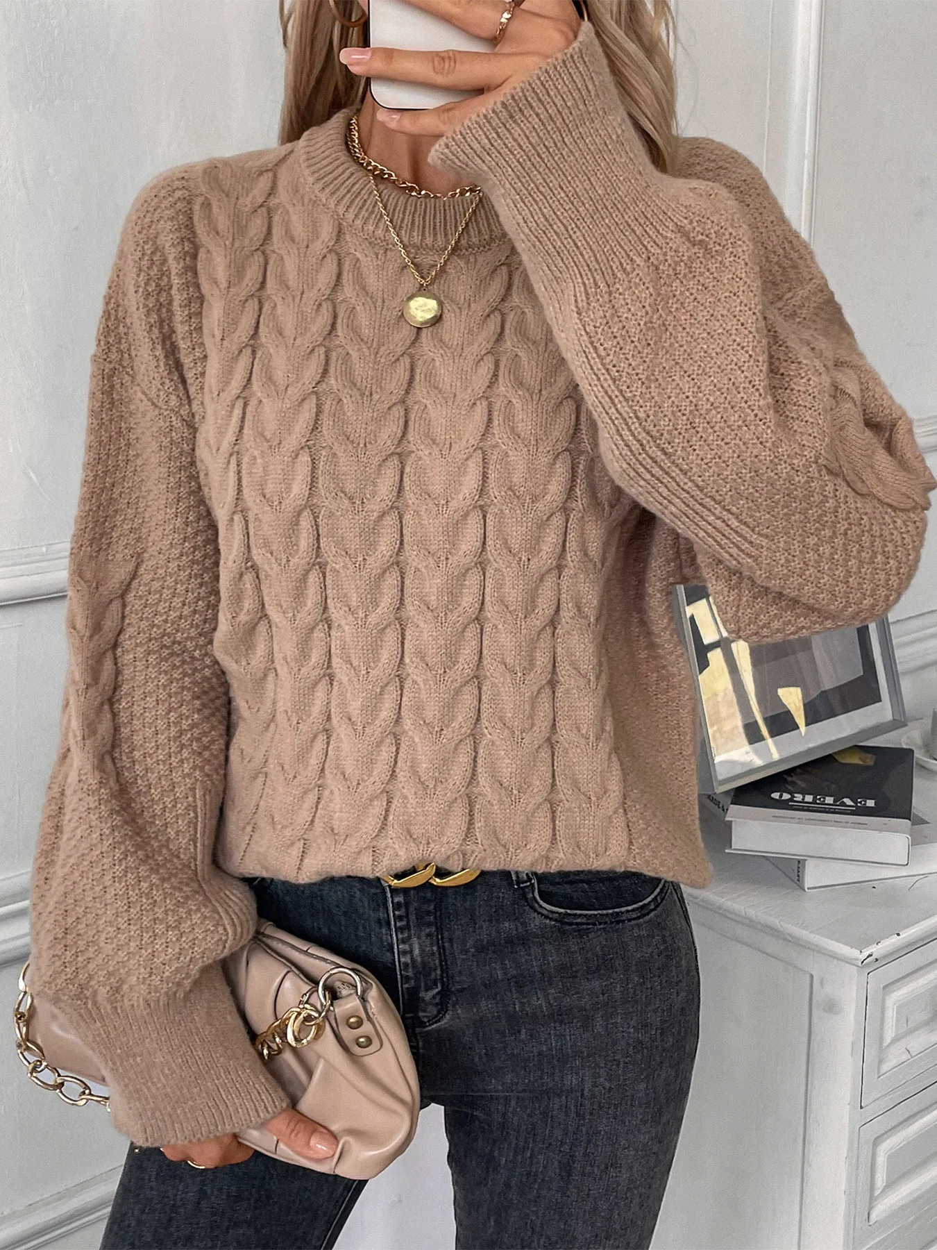Beige women's loose round neck casual pullover sweater with textured thread detail on a hanger.