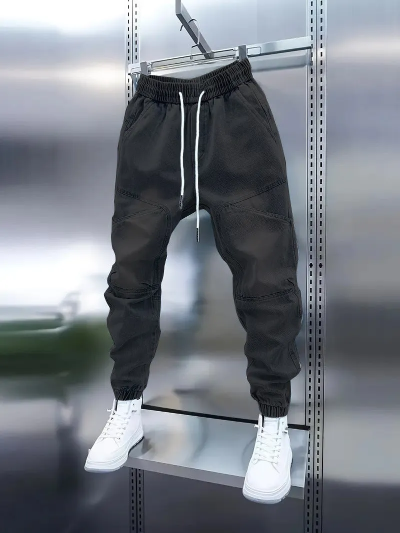 Men's light blue micro-elastic cotton denim pencil trousers with drawstring waist and elastic ankle bands on a model.
