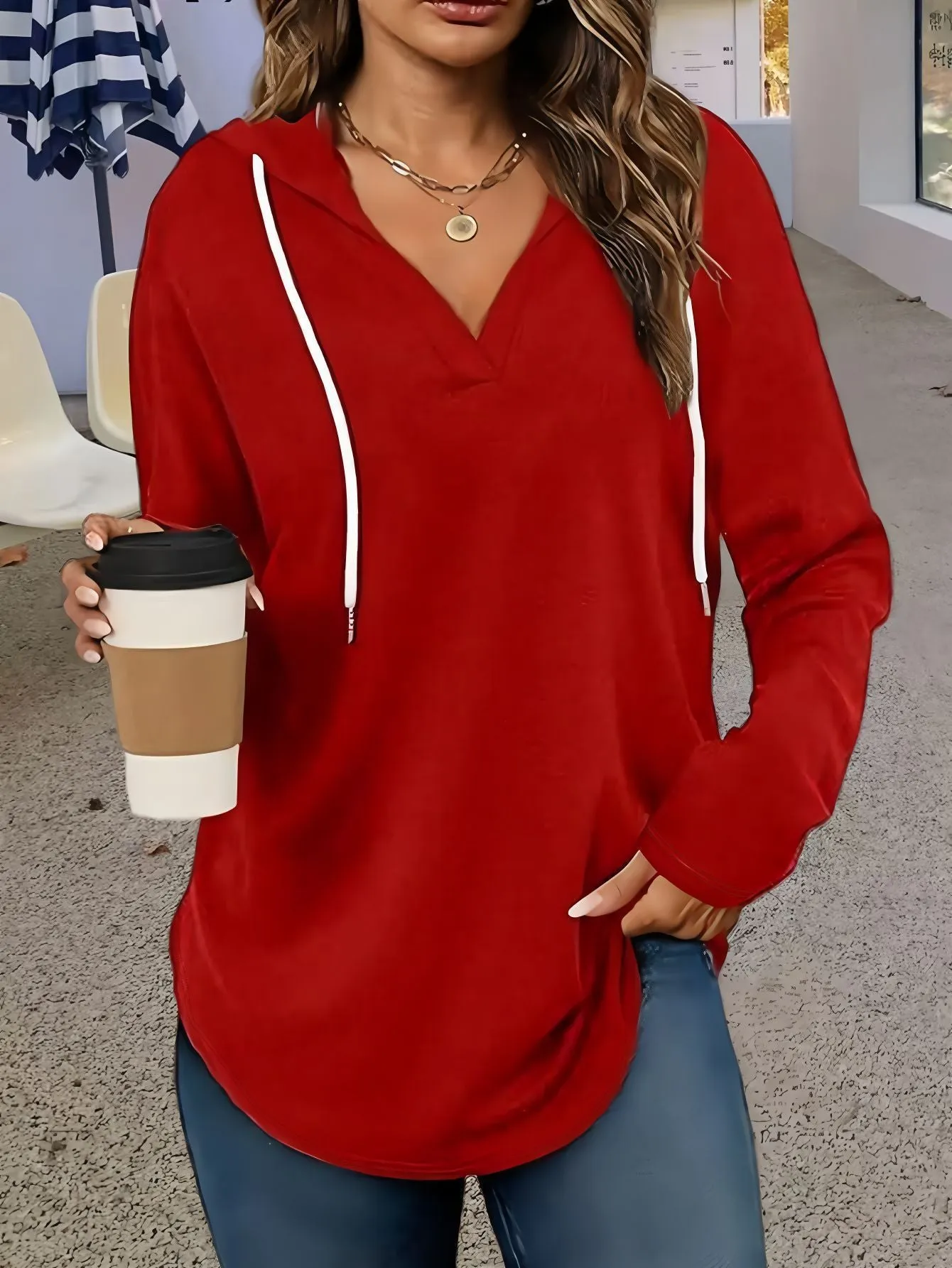 Red women's V-neck hooded sweatshirt with long sleeves on a hanger.
