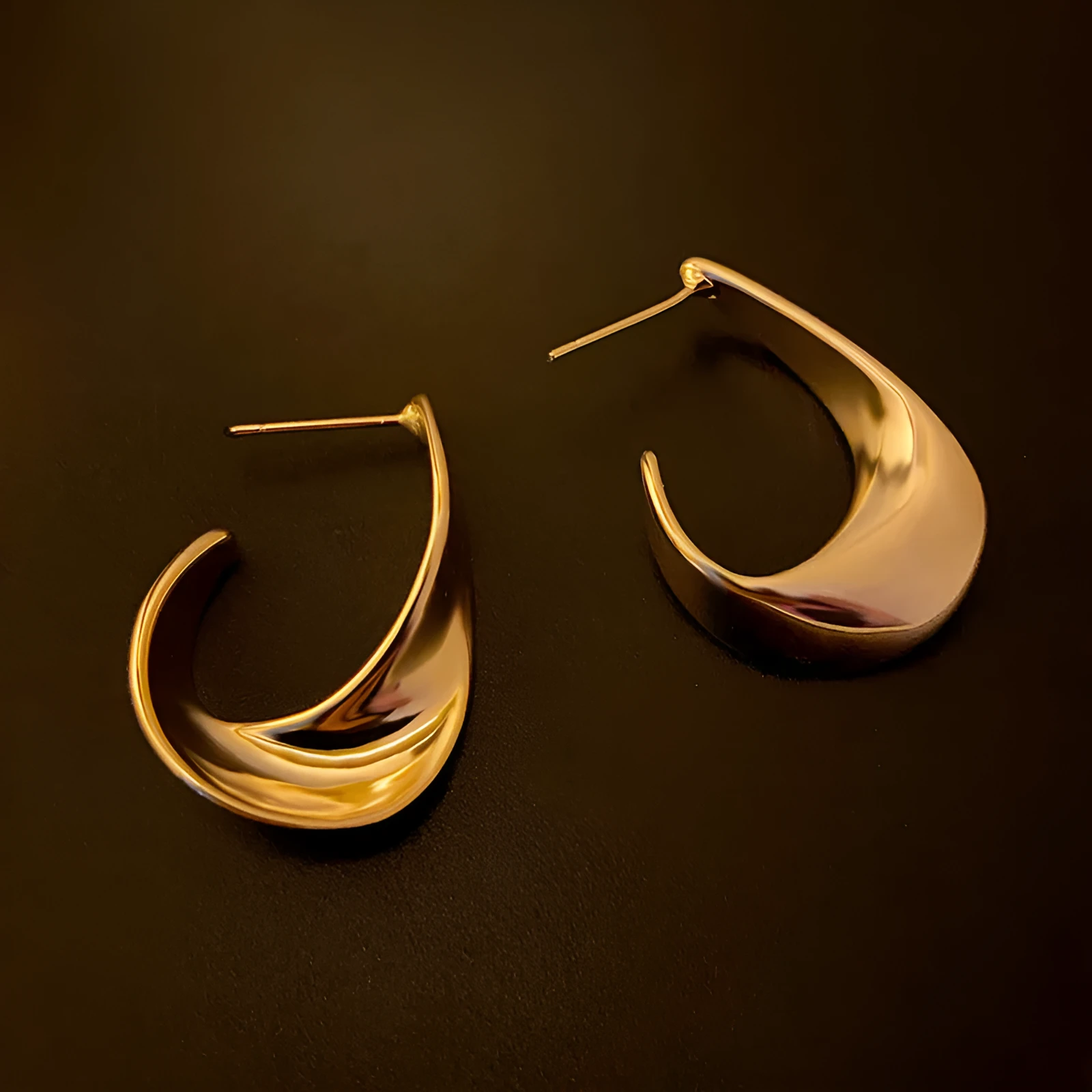 Twisted geometric metal earrings with circular design in gold or silver electroplated finish