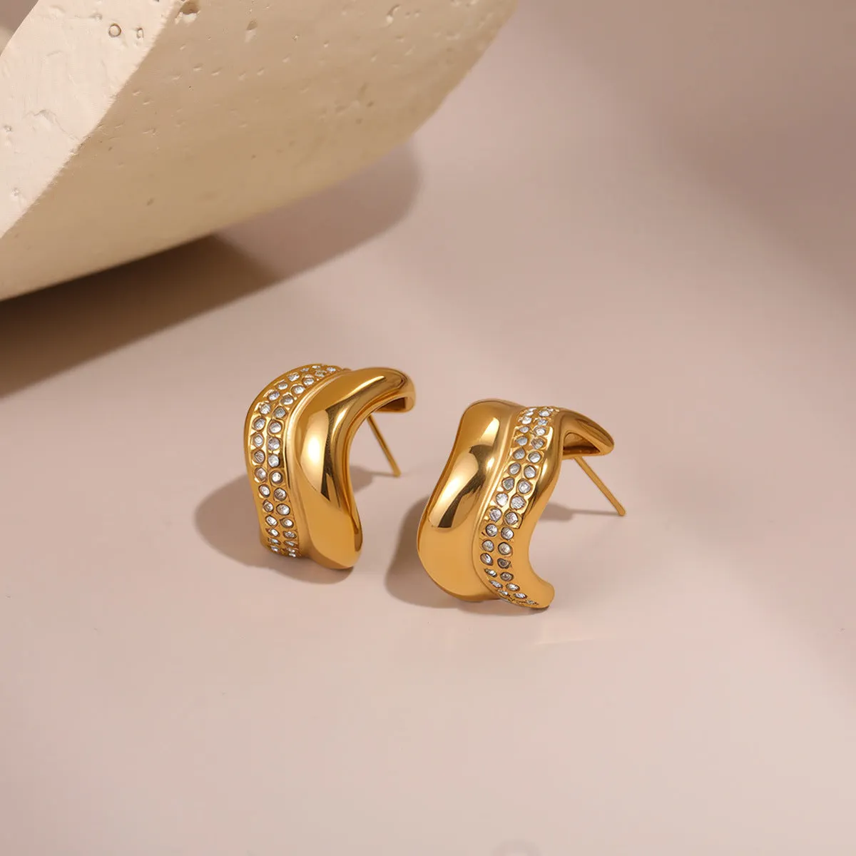 Gold triangle stainless steel geometric stud earrings with electroplated finish on white background