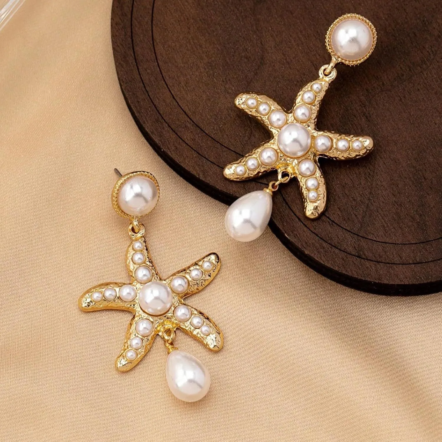 Women's silver-tone pearl starfish earrings on light background