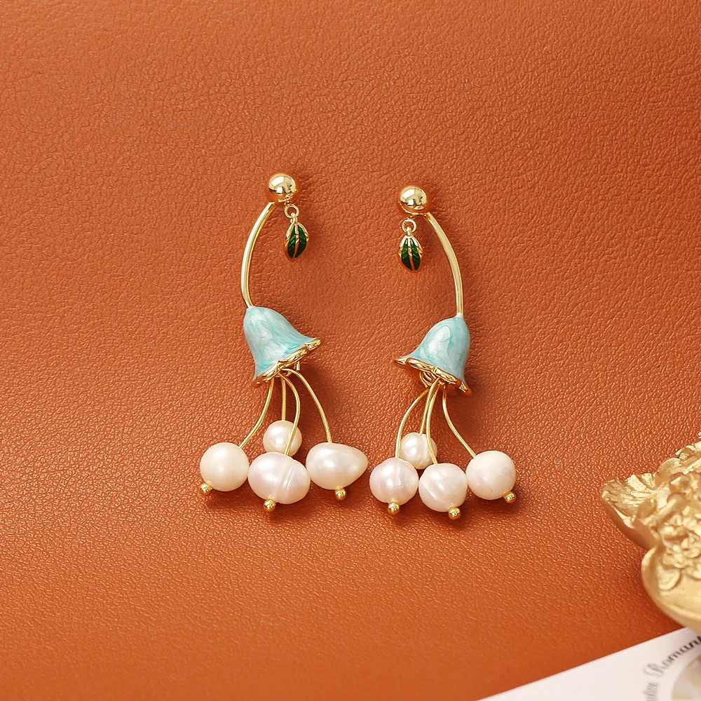 Natural baroque pearl ear studs with 14K real gold plated lily flower copper setting on white background