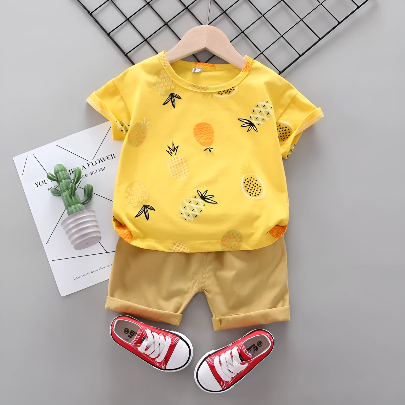 White cotton short-sleeve summer suit set for boys and girls with cartoon print, flat lay