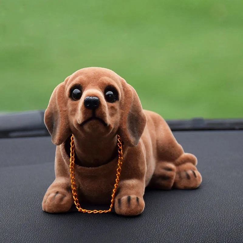 Synthetic resin shake head dog doll in husky design with white auspicious fruit accent on car dashboard