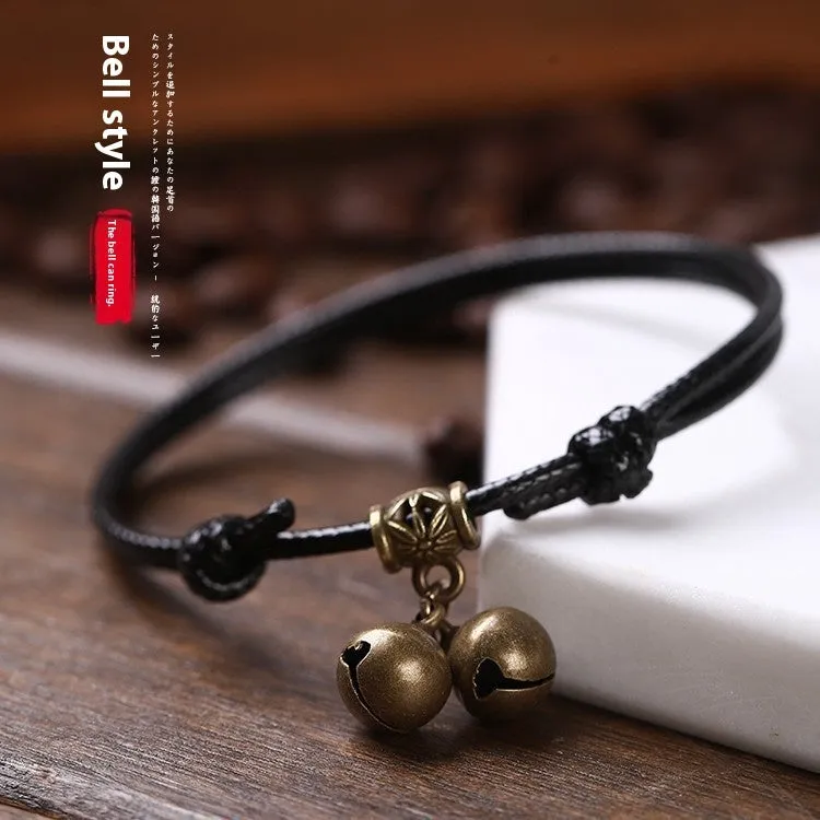 Black nylon rope dog collar with a small brass bell, shown adjusted on a model.