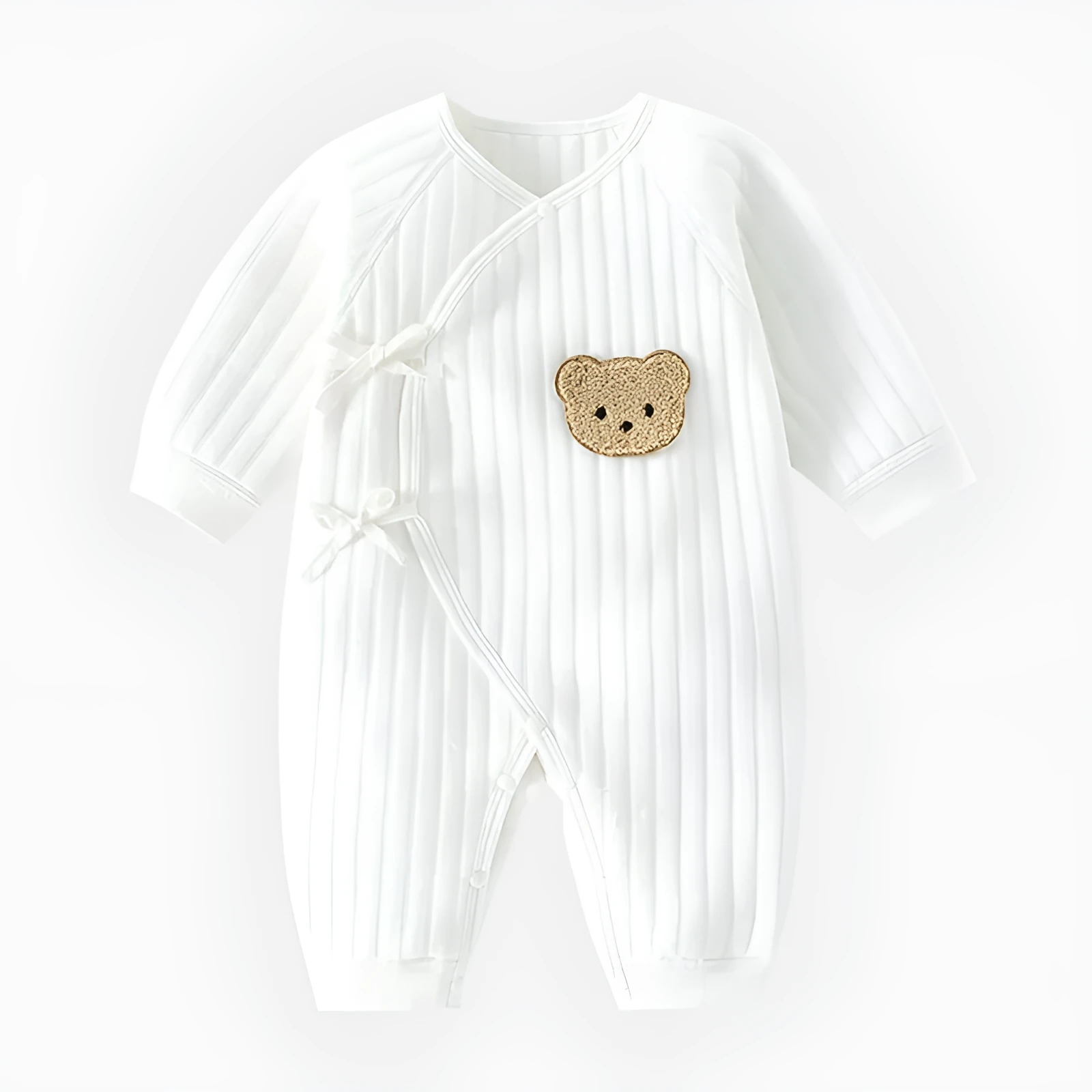 White cotton newborn jumpsuit with top fly lace closure and jacquard teddy bear straps