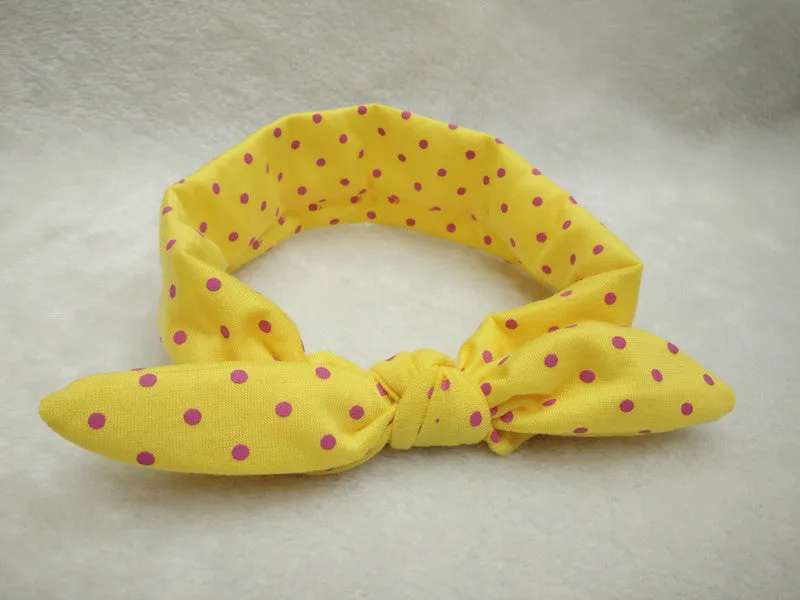 Set of 9 cotton jersey baby headbands in various colours with rabbit ears on white background