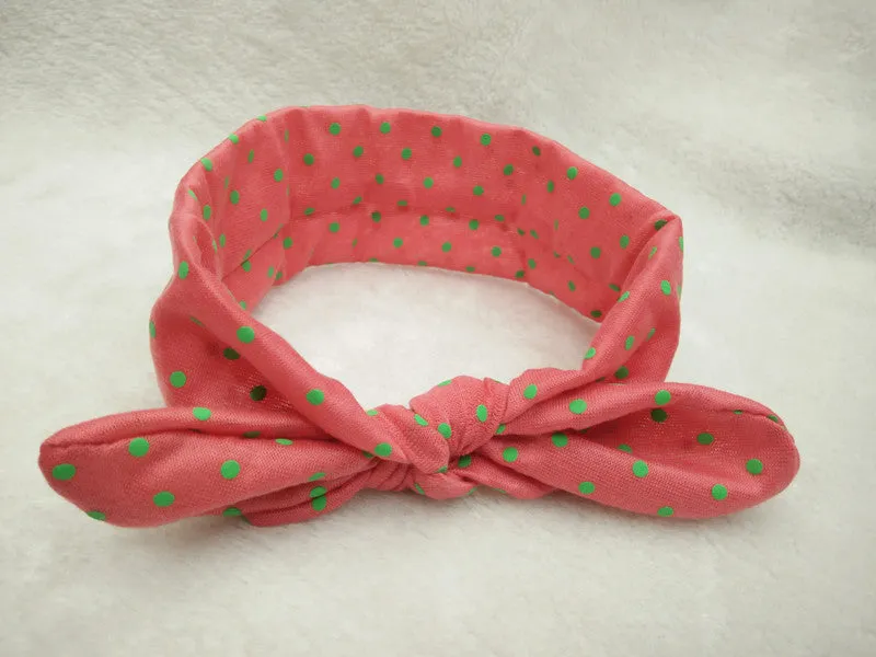 Set of 9 cotton jersey baby headbands in various colours with rabbit ears on white background