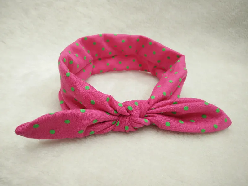 Set of 9 cotton jersey baby headbands in various colours with rabbit ears on white background