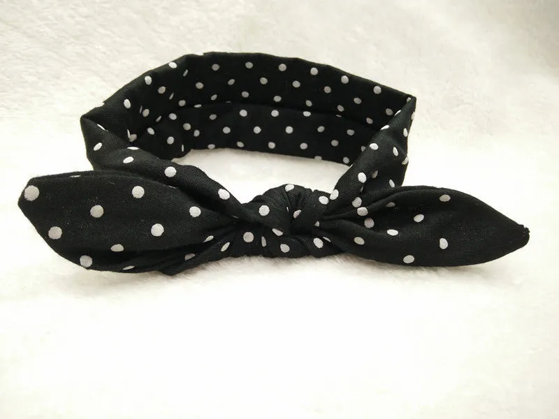 Set of 9 cotton jersey baby headbands in various colours with rabbit ears on white background