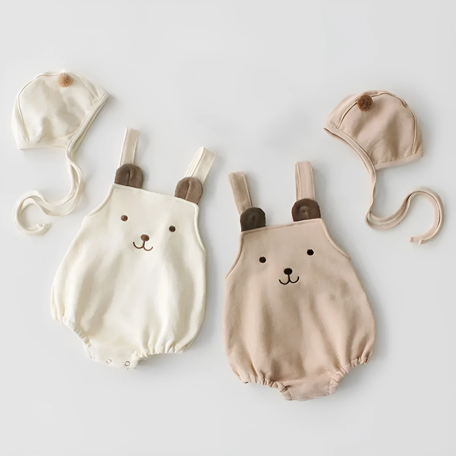 Baby sleeveless strapless cotton robe with detachable hood in brown or white on a plain background