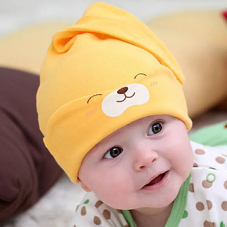 Baby soft cotton sleeping cap with cartoon bear design in blue, gold, and pink colours