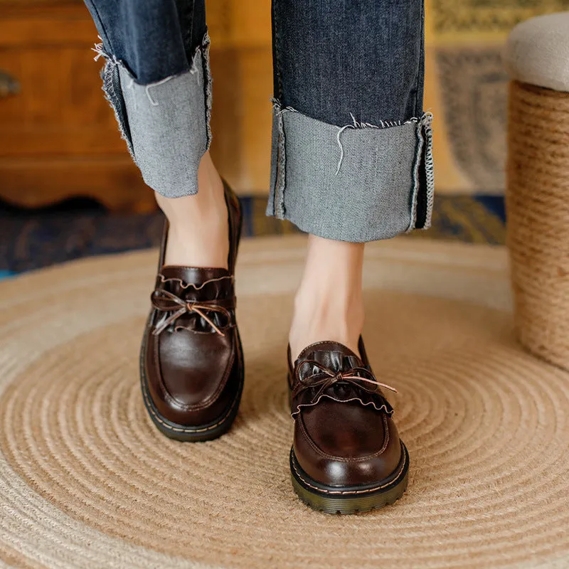 Women's black leather ankle boots with round toe and flat chunky heel, shown from the side.