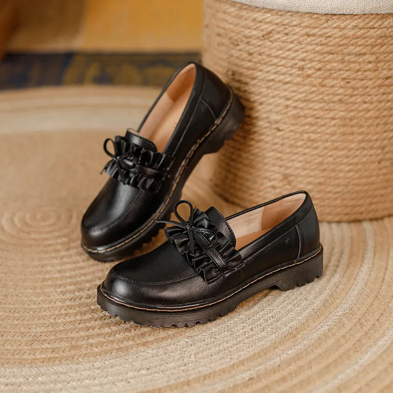 Women's black leather ankle boots with round toe and flat chunky heel, shown from the side.