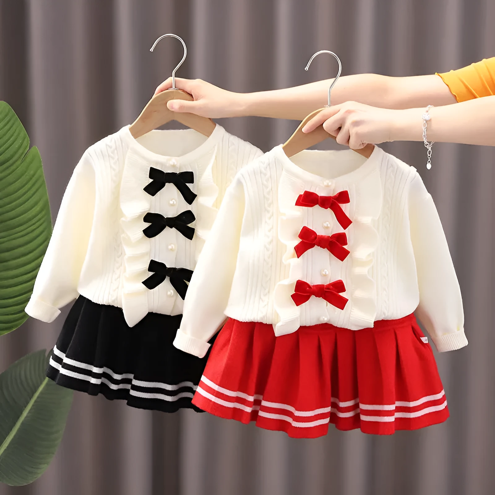 Knitted baby girl two-piece skirt suit in pink with bow detail and long sleeves, autumn wear