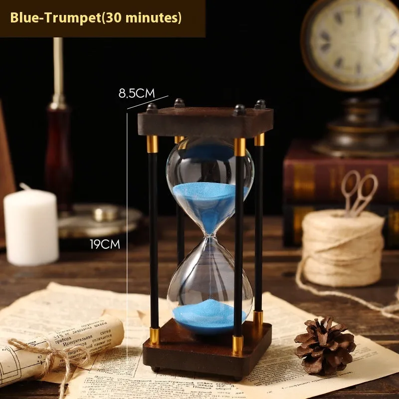 Wooden hourglass timer with solid wood frame and coloured sand on a desk