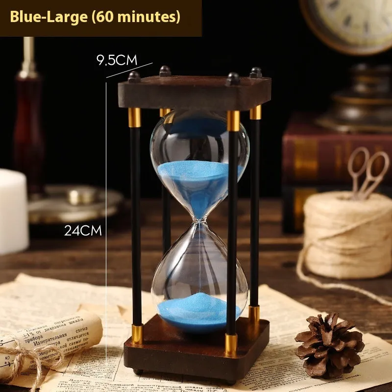 Wooden hourglass timer with solid wood frame and coloured sand on a desk