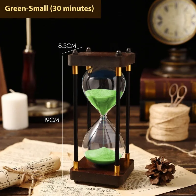 Wooden hourglass timer with solid wood frame and coloured sand on a desk