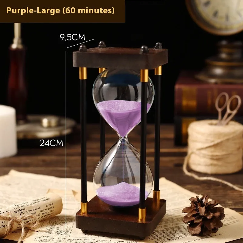 Wooden hourglass timer with solid wood frame and coloured sand on a desk