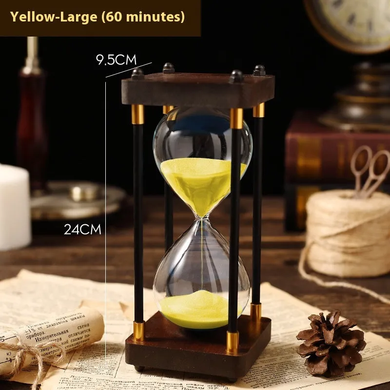 Wooden hourglass timer with solid wood frame and coloured sand on a desk