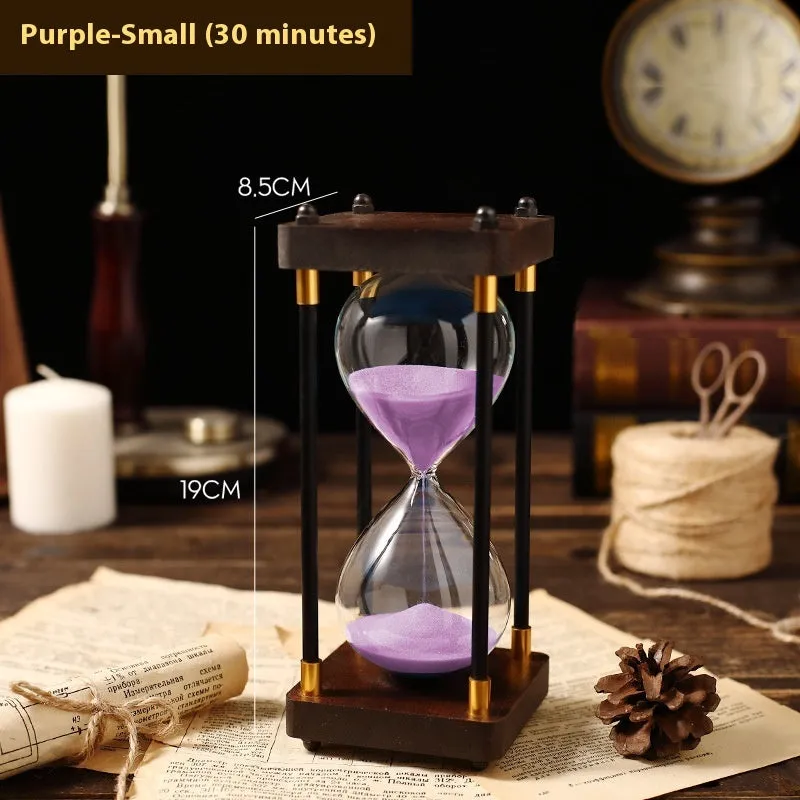 Wooden hourglass timer with solid wood frame and coloured sand on a desk