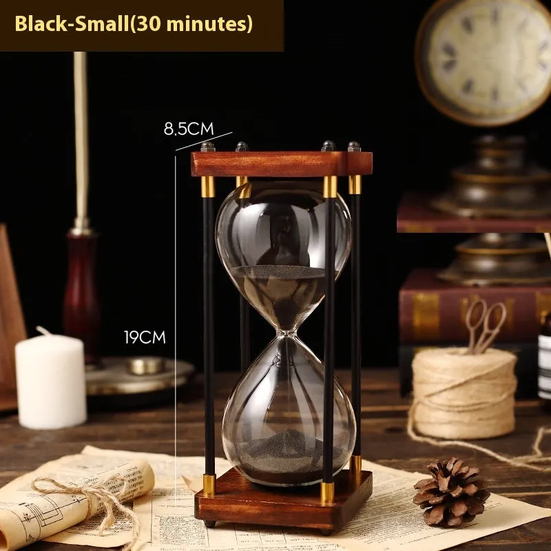 Wooden hourglass timer with solid wood frame and coloured sand on a desk