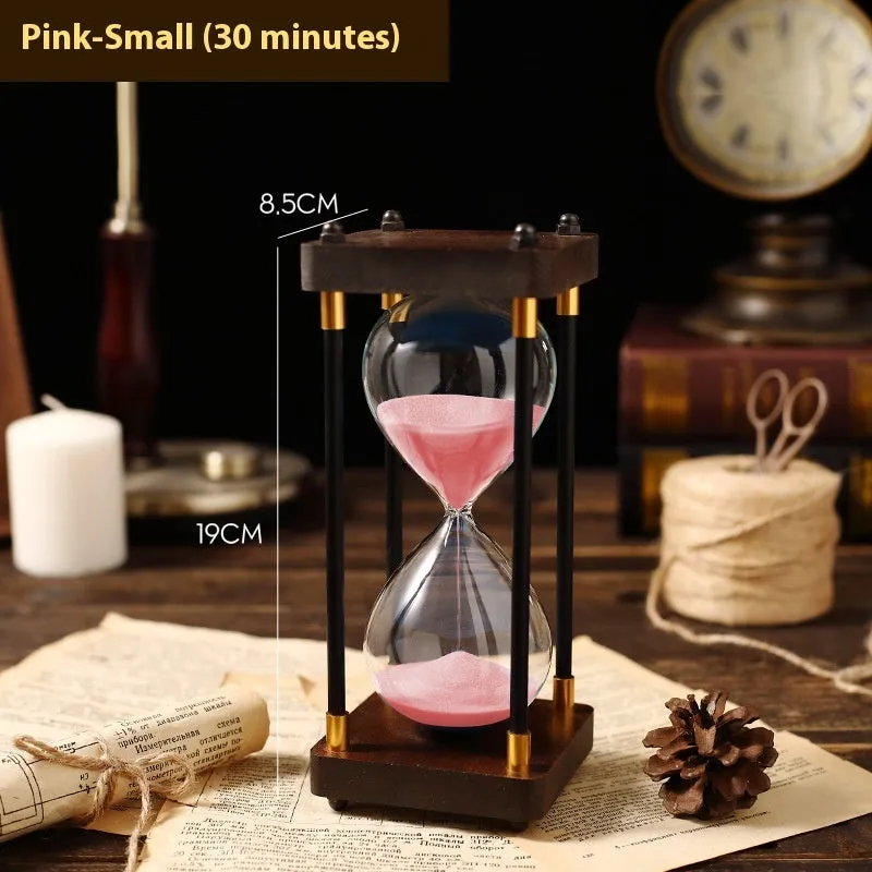 Wooden hourglass timer with solid wood frame and coloured sand on a desk