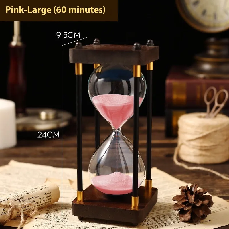 Wooden hourglass timer with solid wood frame and coloured sand on a desk