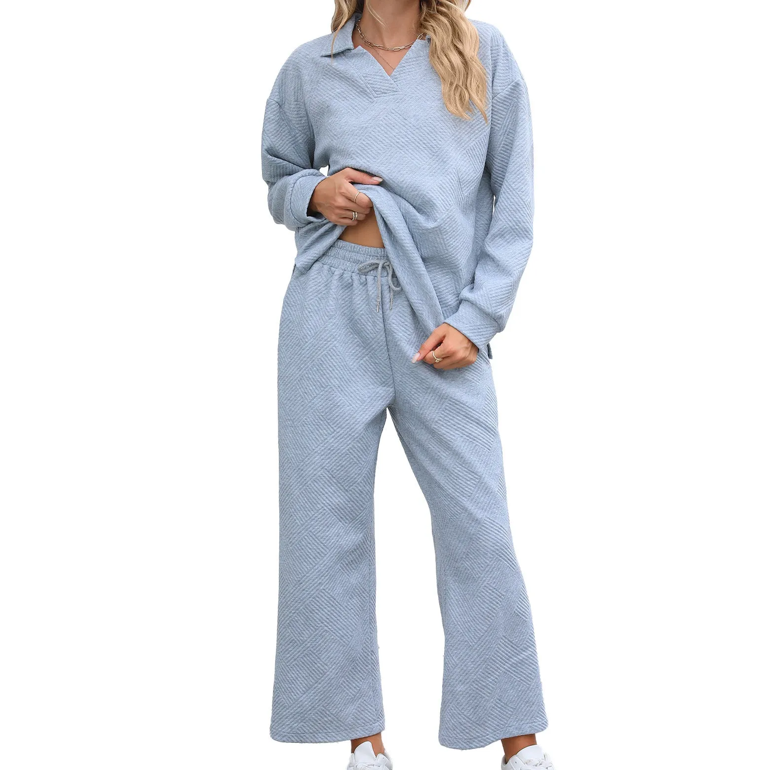 Women's black knitted jacquard long sleeve sweater and elastic waist cropped pants suit on a hanger.