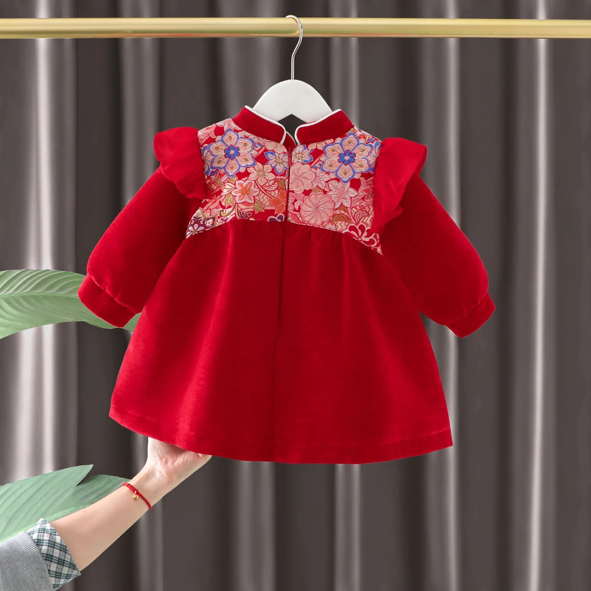 Girls winter velvet padded dress in retro red solid colour with long sleeves, front view on child
