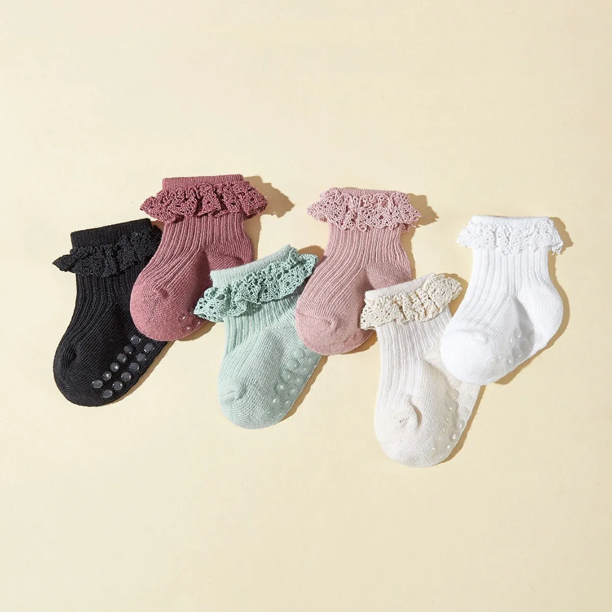 Six pairs of baby girl lace cotton tube socks in mixed colours, short tube length, on white background
