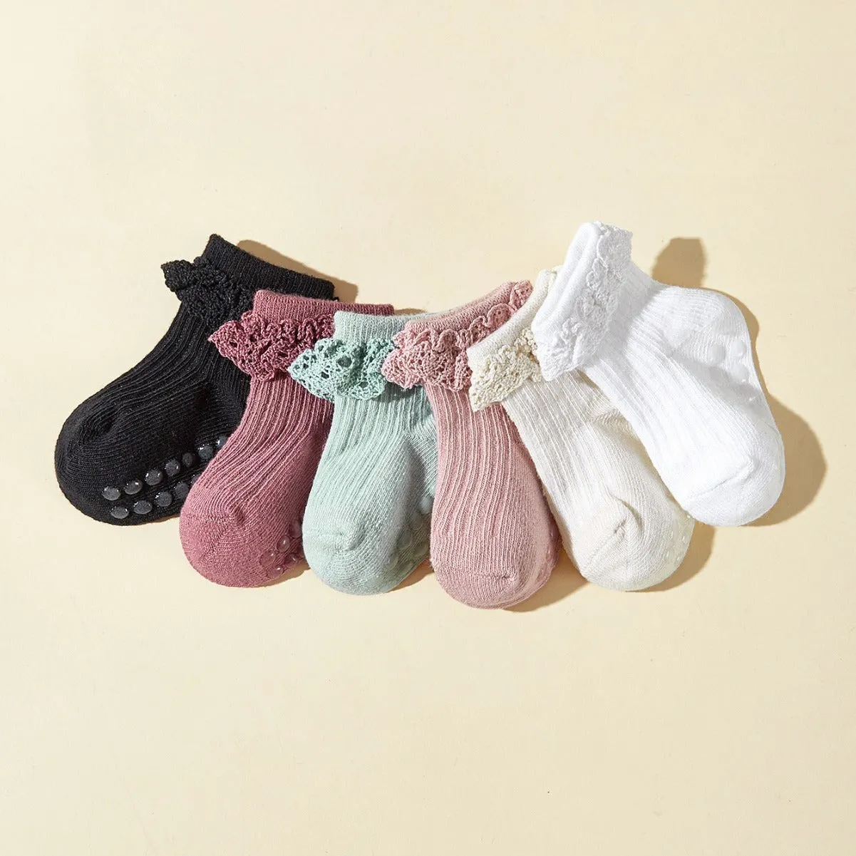 Six pairs of baby girl lace cotton tube socks in mixed colours, short tube length, on white background