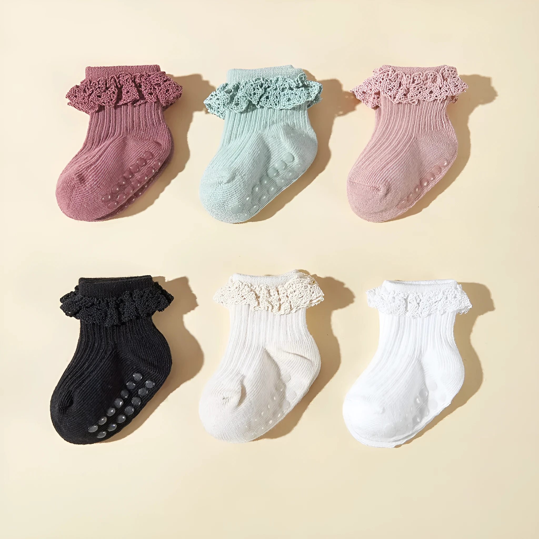 Six pairs of baby girl lace cotton tube socks in mixed colours, short tube length, on white background