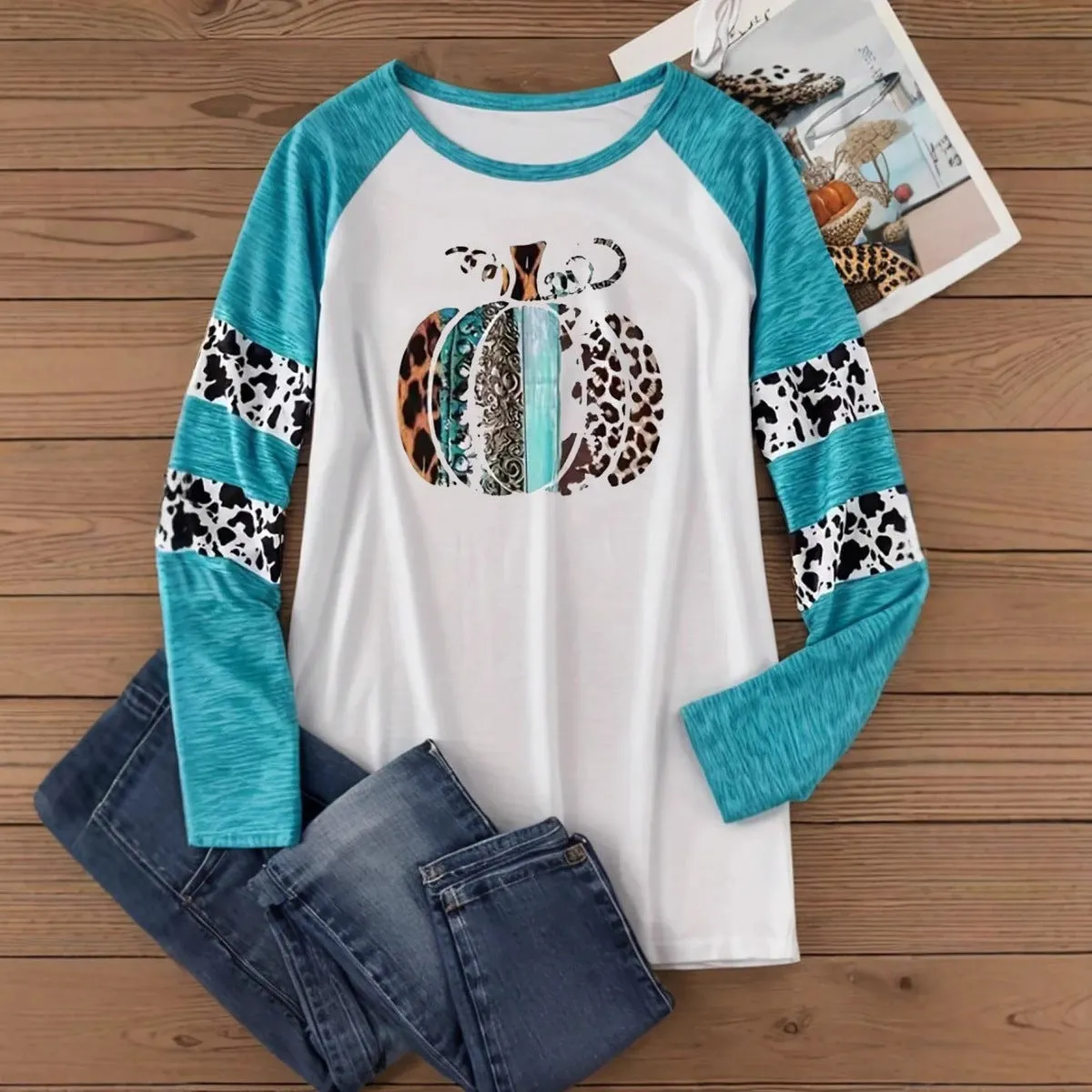 Sky blue long sleeve t-shirt with a white 3D digitally printed Halloween pumpkin graphic.