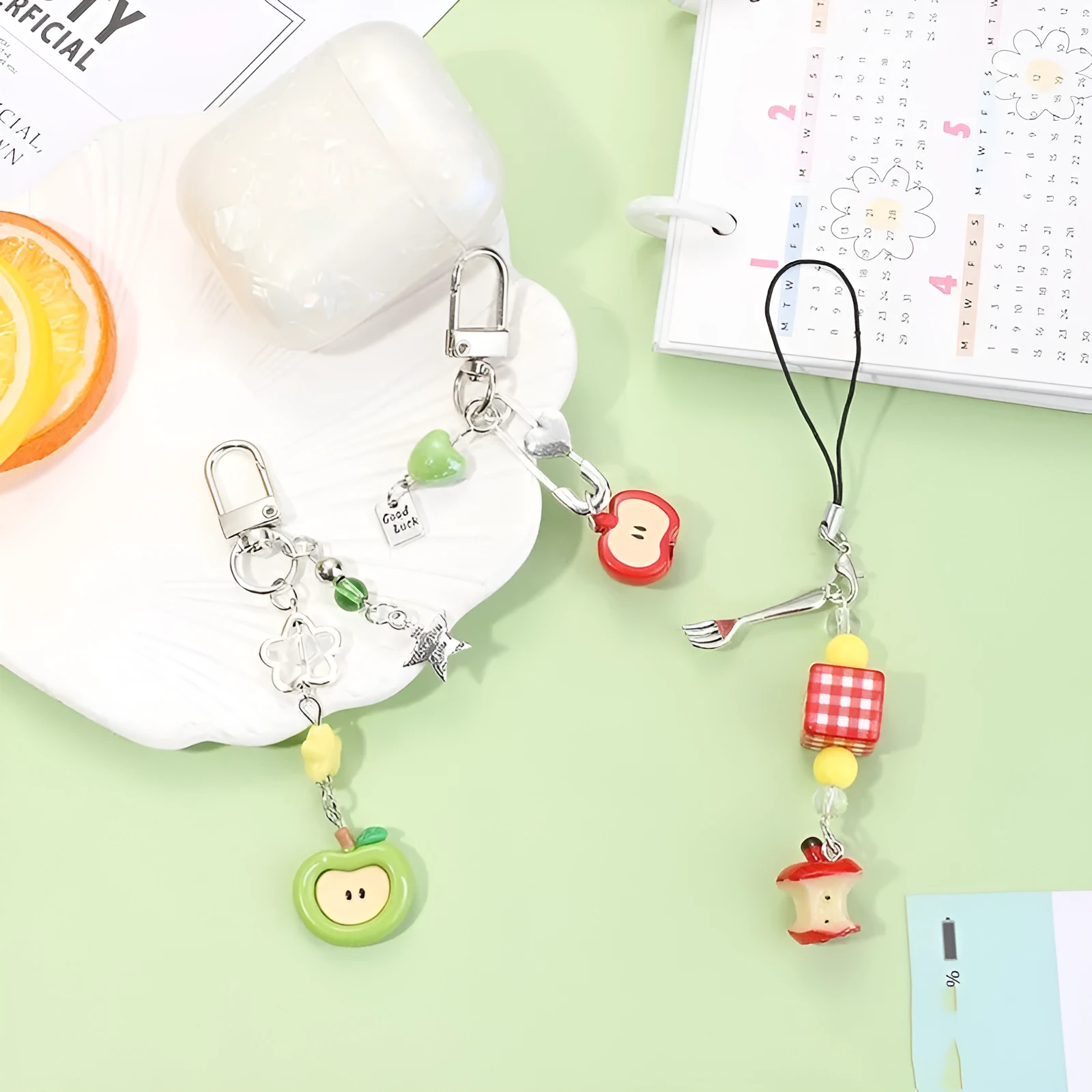 Fruit-themed mobile phone charm keychain with apple and strawberry designs in plastic/resin construction