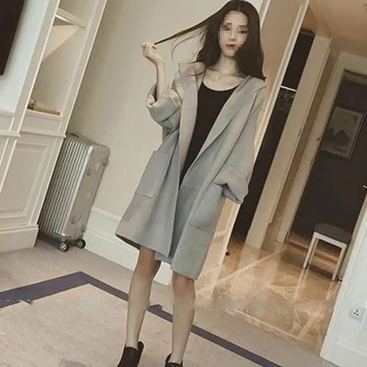 Plus size woman wearing a thin, loose-fit grey coat with lace detail and long sleeves.