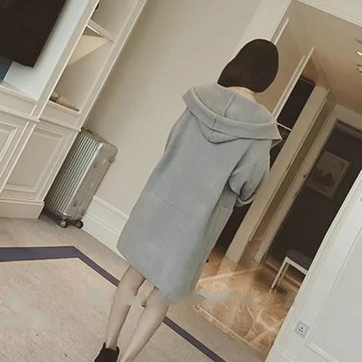 Plus size woman wearing a thin, loose-fit grey coat with lace detail and long sleeves.