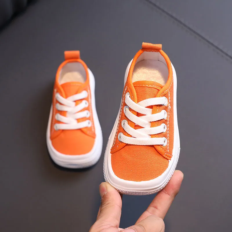 Children's canvas shoes low top sneakers in orange black white leopard print and plaid on a white background