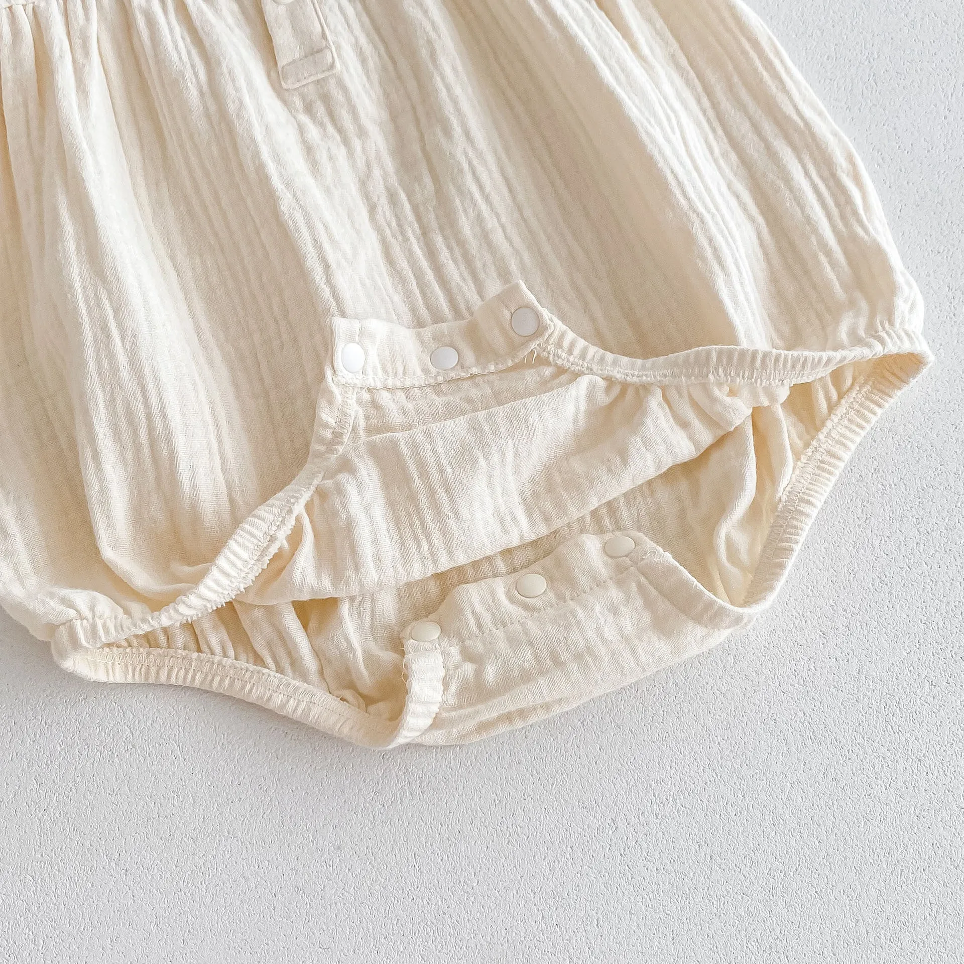 Summer cotton baby jumpsuit in apricot with double-breasted closure and matching hair band